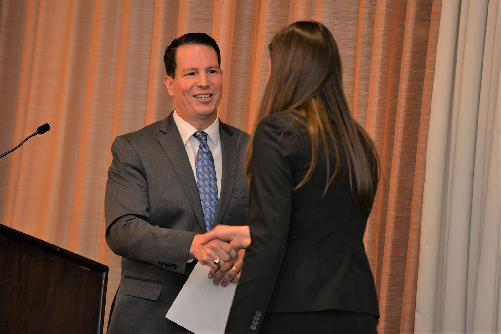 Marketing Associate Professor Rich Rocco hands award to student at Beta Gamma Sigma induction dinner and ceremony